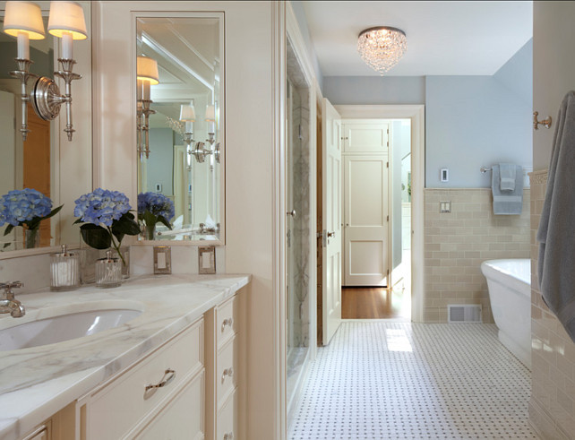 Bathroom Ideas. Bathroom with cream white cabinets and blue paint color on the walls. This bathroom feels classic with its basketweave marble floors and cream white cabinets. #Bathroom #BathroomIdeas #BathroomDesign Designed by Yunker Associates Architecture.
