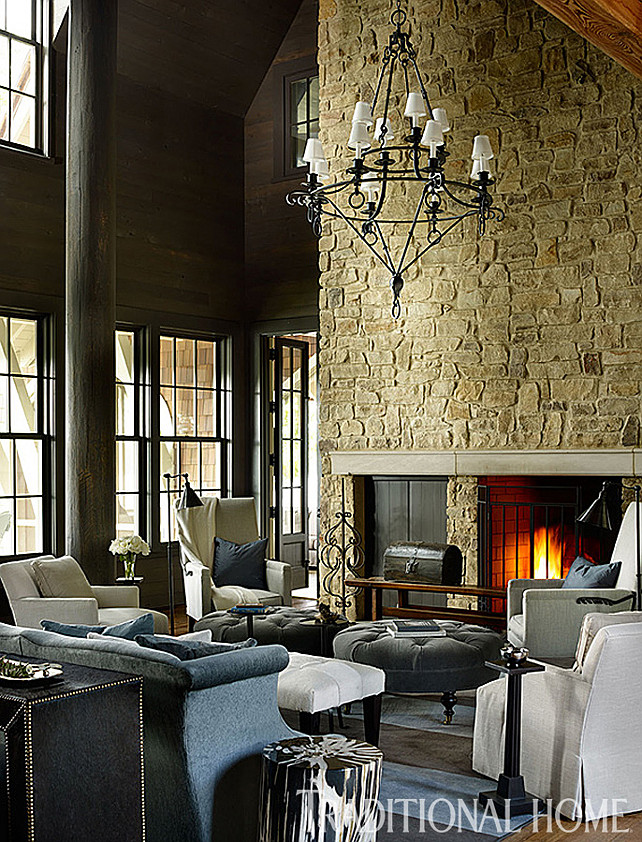 Rustic Lodge Interior Ideas. The interiors of this rustic lodge are tailored and well designed. A stone fireplace adds interest and scale to this living room. Also notice the cozy furniture layout. Pair of tufted ottomans are the “Leather Cocktail Ottoman” #L1014-90, and ottoman fabric (“Flanders”/Coal), both from Lee Industries. #Interiors #RusticInteriors #Lodge #Homedecor