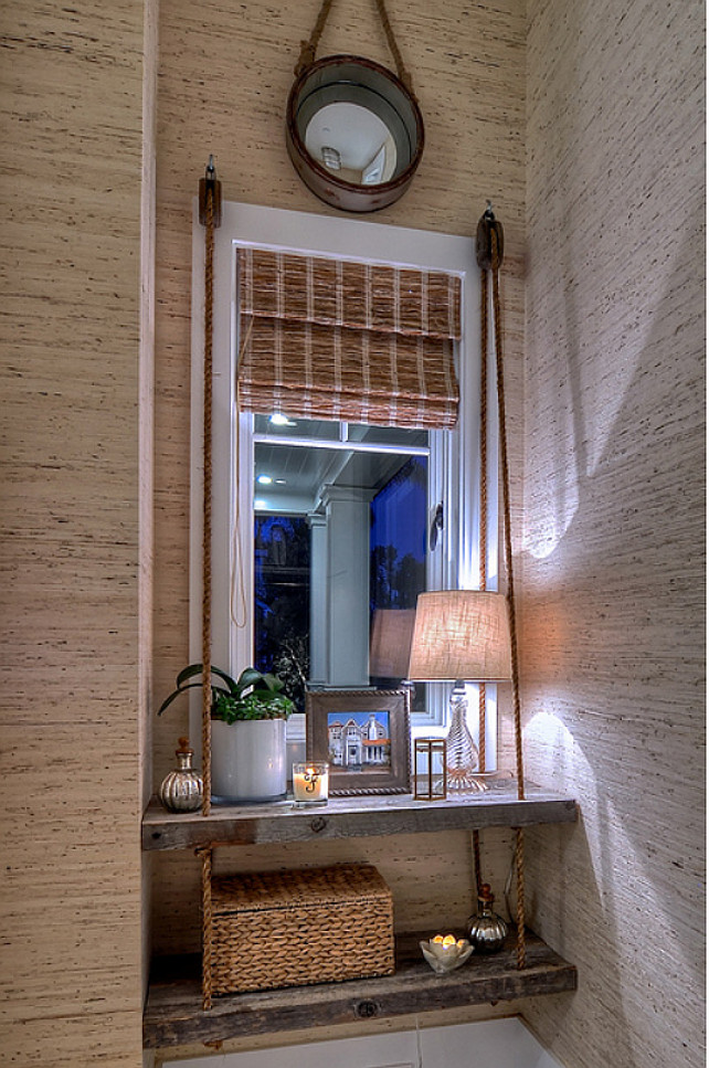 Coastal Decor Ideas. Natural wood shelves are strung from custom hemp ropes to create an eye catching design in this recessed window area. #CoastalDecor #InteriorDesignIdeas #CoastalDecorIdeas