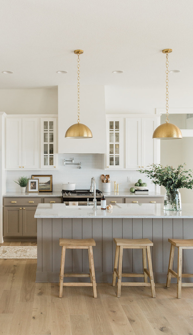Warm white and neutral taupe cabinets along with brass accents create a kitchen that is inviting and easy to be at Nothing here feels rash nor overly trendy #Warmwhite #neutrals #taupecabinet #brassaccents #kitchen #trendy