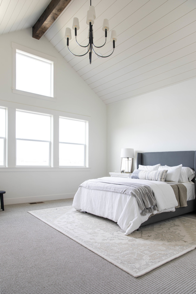 Plenty of natural light vaulted shiplap ceilings with a box beam accentuate by a large chandelier along with carpet flooring bring a calming feel to the primary bedroom #naturallight #vaultedshiplapceiling #boxbeam #largechandelier #carpetflooring #primarybedroom #bedroom