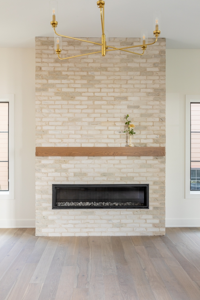 In the great room windows flank a fireplace clad in brick from floor to ceiling along with a white oak mantel