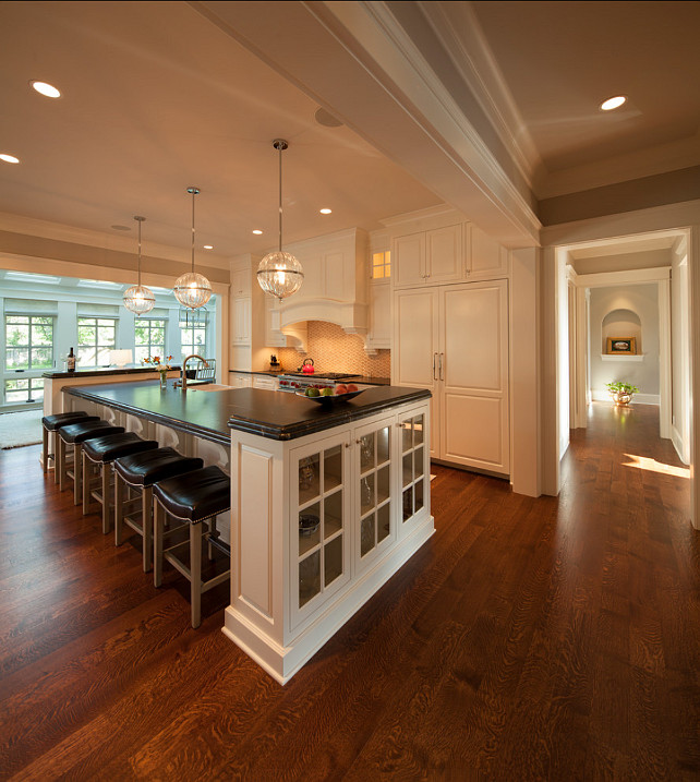 Kitchen Design. The floors are 5" Rift & Quarter Sawn White Oak, Select Grade, with a custom-blended stain. Kitchen Pendants are "Janus globe pendant from Cyan Design". Cabinets are painted in Benjamin Moore White Dove OC17. #KitchenDesign #Kitchen #KitchenIdeas #WhiteKicthen