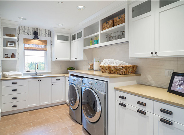 Laundry Room Ideas. Laundry Room Cabinet Ideas. This laundry room features birch wallpaper, slab quartz, open shelves, lighting by Hudson valley, washer & dryer, ORB cup pulls, glass cabinet doors, tile floors and textured white tile backsplash. Countertop is "Caesarstone 2370 Mocha". #LaundryRoom #LaundryRoomCabinet
